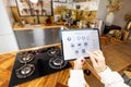 Woman holding digital tablet with running smart home application in the kitchen Royalty Free Stock Photo