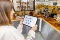 Woman holding digital tablet with running smart home application in the kitchen Royalty Free Stock Photo