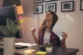 Woman holding documents joyful after a business success