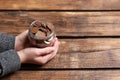 Woman holding donation jar with coins at table, closeup. Space for text Royalty Free Stock Photo