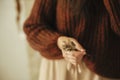 Woman holding dried herb close up in rustic room. Details of making stylish autumn wreath. Fall decor and arrangement in farmhouse