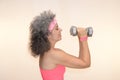 Woman 50+ holding dumbbells Grey hair Sweatband