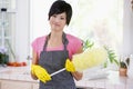 Woman Holding Duster And Wearing Rubber Gloves