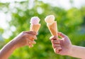 Woman holding and eating ice cream in the park. Hands holding melting ice cream waffle cone in hand on summer nature light  backgr Royalty Free Stock Photo