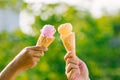 Woman holding and eating ice cream in the park. Hands holding melting ice cream waffle cone in hand on summer nature light  backgr Royalty Free Stock Photo