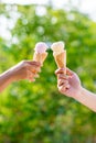 woman holding and eating ice cream in the park. Hands holding melting ice cream waffle cone in hand on summer nature light backgr Royalty Free Stock Photo