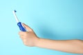 Woman holding electric toothbrush