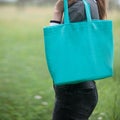 Woman holding emerald green tote bag, outdoor Royalty Free Stock Photo