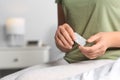 Woman holding emergency contraception pills in bedroom, focus on hands. Space for text Royalty Free Stock Photo