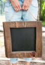 Woman holding empty blackboard with wooden frame. Template Mock Royalty Free Stock Photo