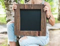 Woman holding empty blackboard with wooden frame. Template Mock Royalty Free Stock Photo