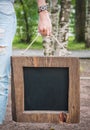 Woman holding empty blackboard with wooden frame. Template Mock Royalty Free Stock Photo