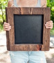 Woman holding empty chalkboard with wooden frame. Template Mock Royalty Free Stock Photo