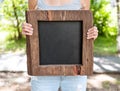 Woman holding empty chalkboard with wooden frame. Template Mock Royalty Free Stock Photo