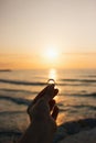 Woman holding the engagement ring in hand in the time sunrise on sea. An offer of marriage on beach of Italy Royalty Free Stock Photo