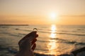 Woman holding the engagement ring in hand in the time sunrise on sea. An offer of marriage on beach of Italy Royalty Free Stock Photo