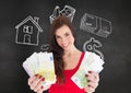 Woman holding euro cash against blackboard in background