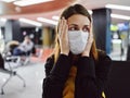 woman holding face nifiga mask waiting airport flight delay