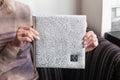 Woman holding a family photobook. White photo album in female hands. Wedding or family photoalbum with cover of genuine leather.