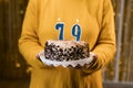 Woman holding a festive cake with number 79 candles while celebrating birthday party. Birthday holiday party people