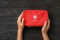 Woman holding first aid kit on dark table Royalty Free Stock Photo