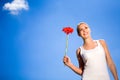 Woman holding flower against blue sky Royalty Free Stock Photo