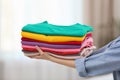 Woman holding folded clean clothes indoors. Laundry day Royalty Free Stock Photo
