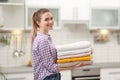 Woman holding folded clean towels in kitchen Royalty Free Stock Photo