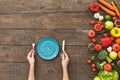 Woman holding fork, knife, in front of her plate, vegetables