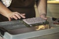 A woman holding a frame for making paper sheets from recycled paper. Selective focus. Household hobby, paper recycling