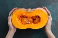 Woman holding fresh half of pumpkin