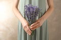 Woman holding fresh lavender flowers on beige background Royalty Free Stock Photo