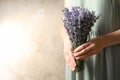 Woman holding fresh lavender flowers on beige background. Space for text Royalty Free Stock Photo