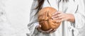 Woman holding a freshly baked round loaf of bread