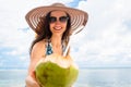 Woman holding freshly opened coconut at tropical beach Royalty Free Stock Photo