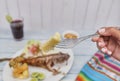 Woman holding a Fried yucca, Peruvian cuisine: Cabrilla frita, fried fish, Selective Focus Royalty Free Stock Photo