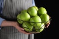 Woman holding fruit bowl with green apples against black background, closeup Royalty Free Stock Photo