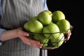 Woman holding fruit bowl with green apples against black background, closeup Royalty Free Stock Photo