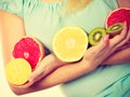 Woman holding fruits kiwi. orange, lemon and grapefruit