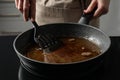 Woman holding frying pan with used cooking oil