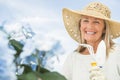 Woman Holding Gardening Fork And Trowel Against Sky