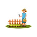 Farmer woman holding gardening spade and basket with harvest. Vegetable garden with green salad. Wooden fence on