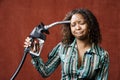 Woman Holding Gas Nozzle to her Head