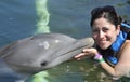 Woman holding a kiss from a dolphin.