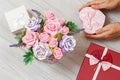 Woman holding a gift box in the hands with flowers on the background Royalty Free Stock Photo