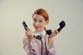 Woman holding, giving two telephones smiling at camera Royalty Free Stock Photo