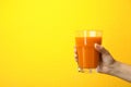Woman holding glass of carrot juice on color background Royalty Free Stock Photo