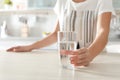 Woman holding glass with clean water on table Royalty Free Stock Photo