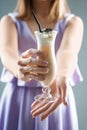 Woman holding glass of cold frappe coffee, closeup