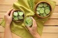 Woman holding glass of fresh cucumber water and sliced vegetable on wooden background Royalty Free Stock Photo